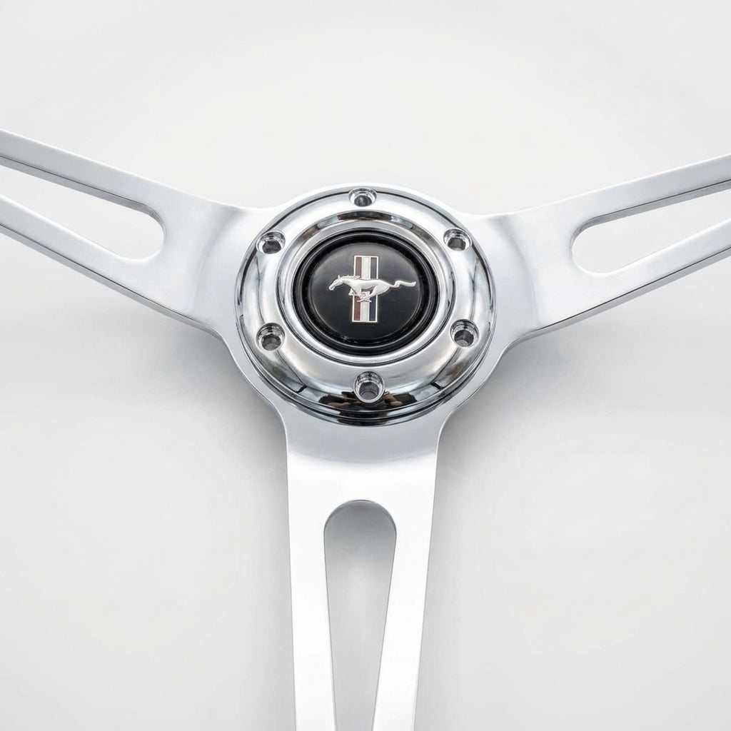 A close-up of a polished chrome steering wheel rim with a black center cap featuring the silver Mustang horse logo.