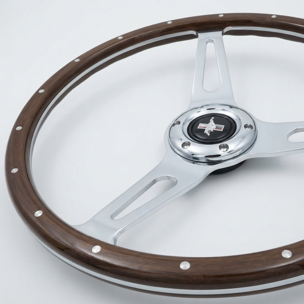 A vintage-style steering wheel with a dark brown wood rim, polished silver metal spokes, and a central chrome hub featuring a black Mustang logo.