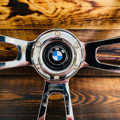 14 wood steering wheel for BMW with polished metal spokes on wooden background