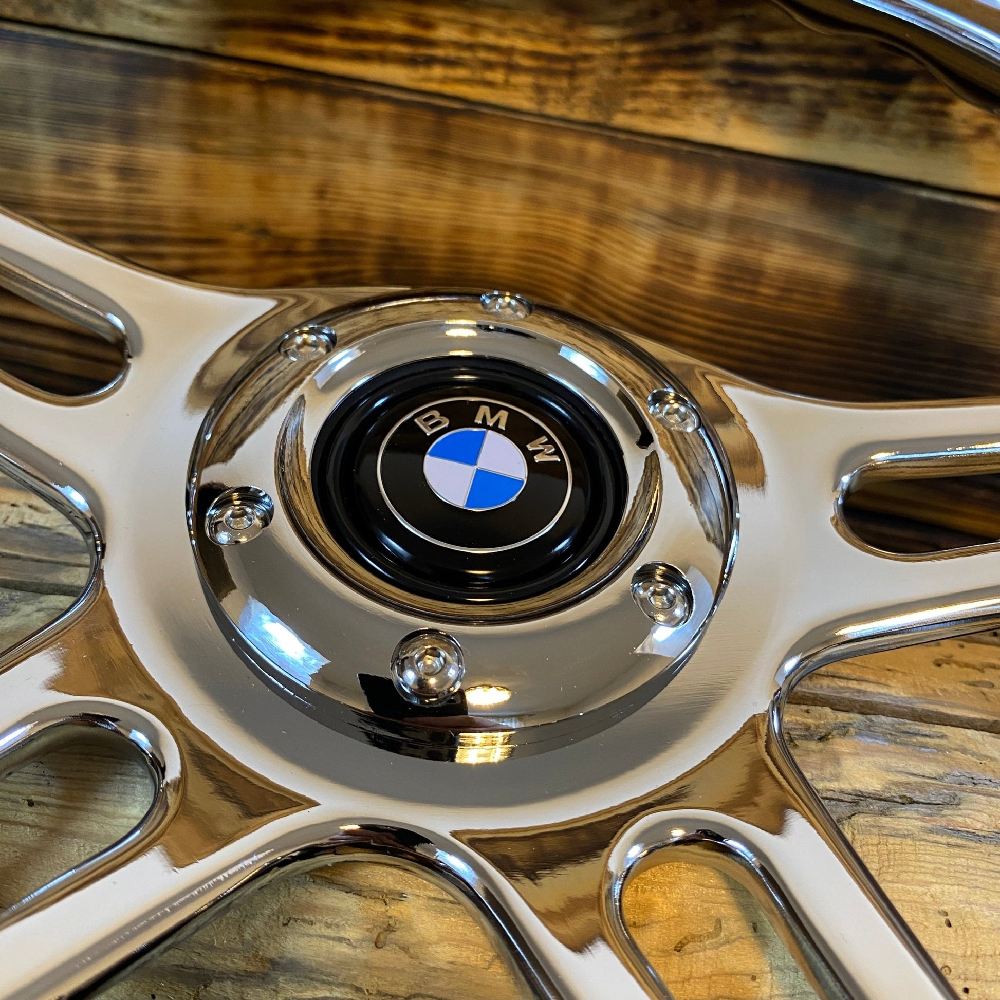 Close-up of 14 inch wood steering wheel BMW by Punk Wheels showing polished metal spokes and BMW center emblem