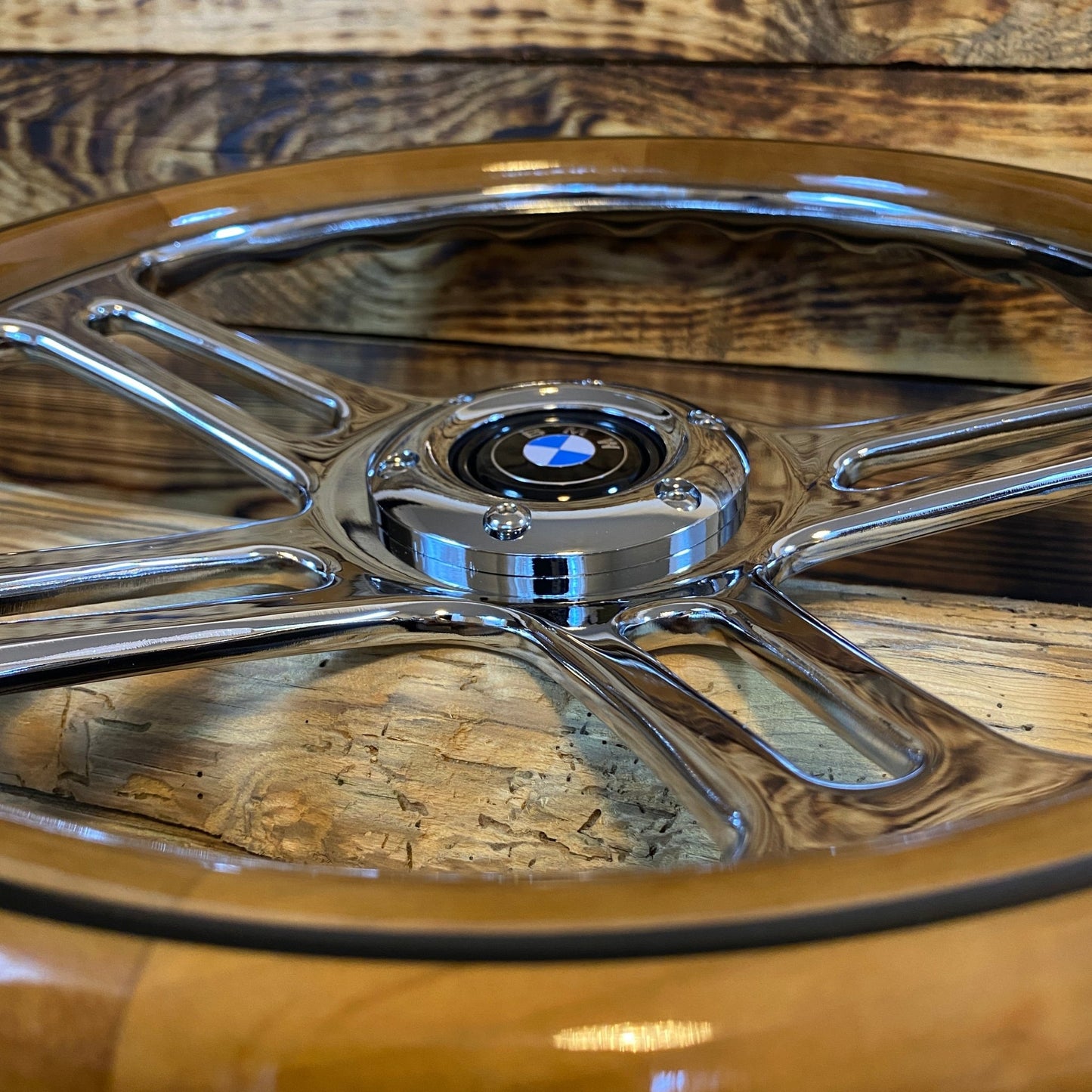 14 inch wood steering wheel bmw with polished metal spokes and center cap viewed close-up