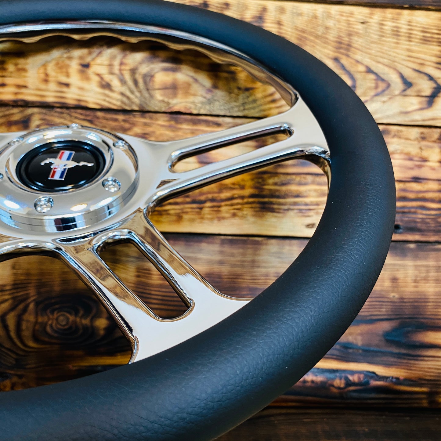 14 inch leather aftermarket steering wheel for Mustang with chrome spokes and black grip shown from top angle
