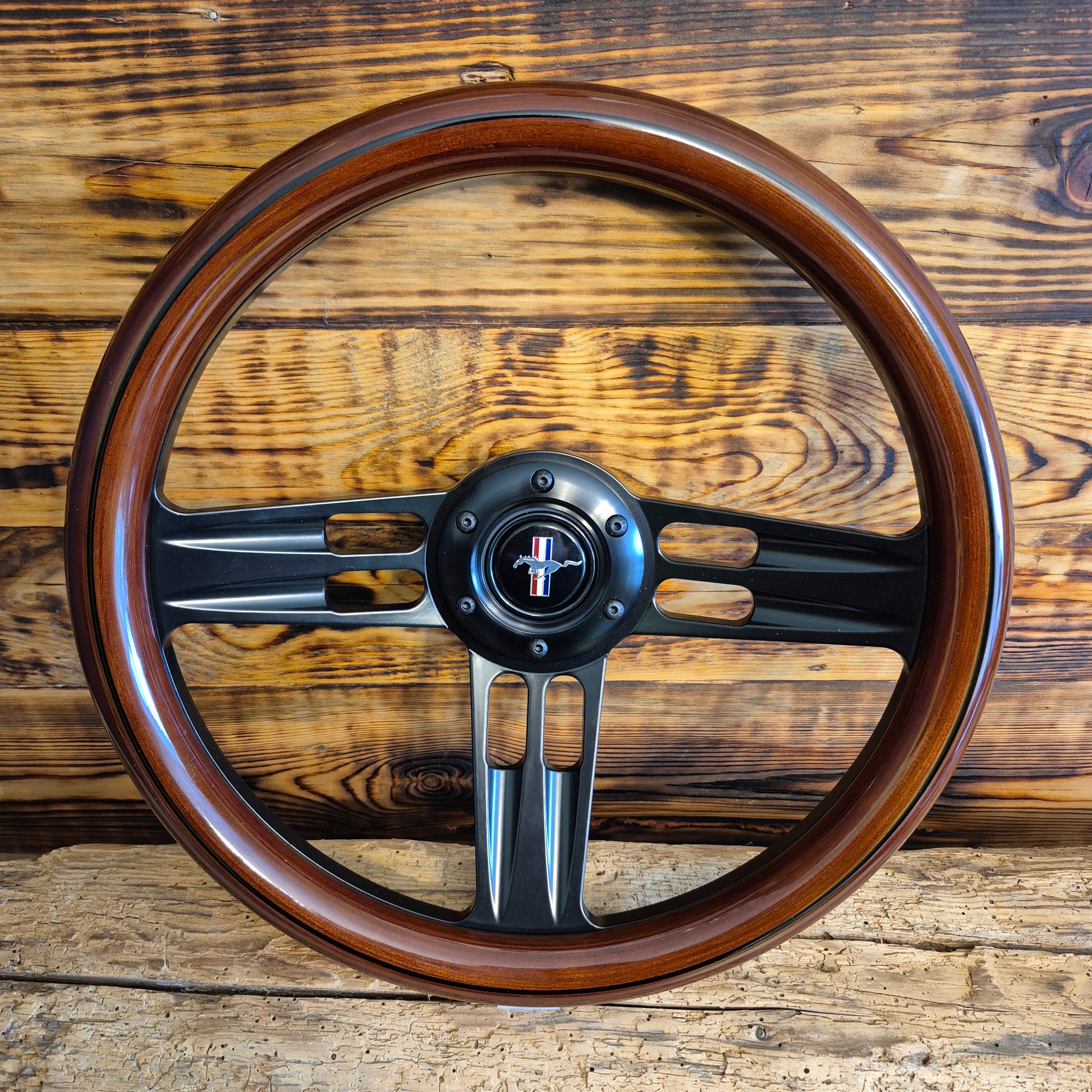 14 inch wood steering wheel for Ford Mustang with black metal spokes and Mustang emblem center front view