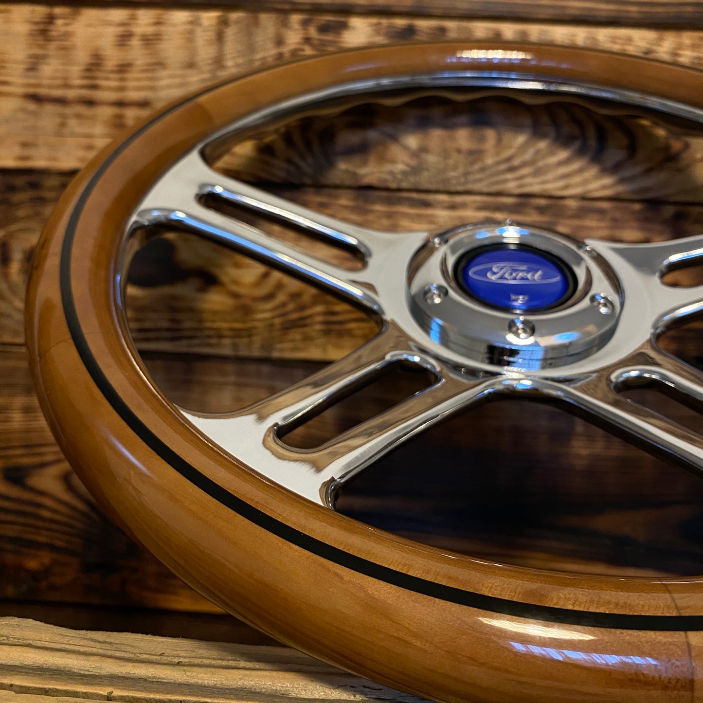 14 inch wood steering wheel for Ford with polished metal spokes and blue Ford center emblem close-up view