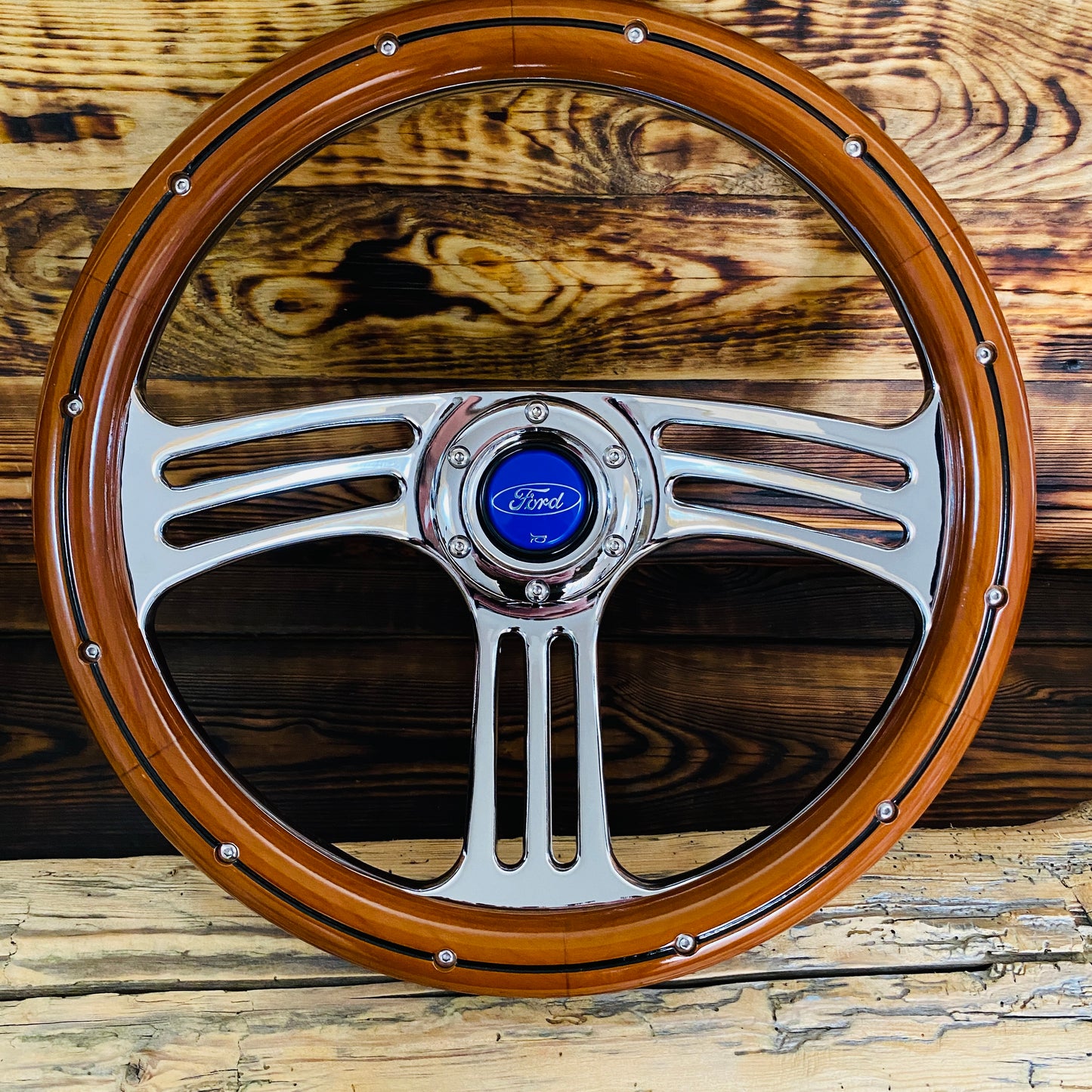 14 inch Ford wood steering wheel with polished metal spokes and blue Ford emblem front view
