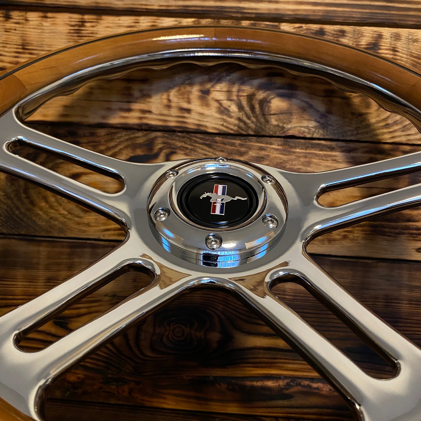 14 inch wooden steering wheel for Mustang with polished metal spokes and pony emblem center viewed from front