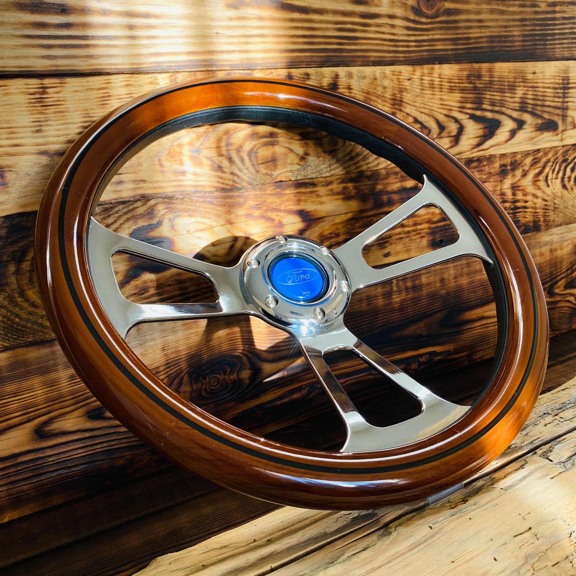 14 inch Ford wooden steering wheel with polished metal spokes and blue Ford horn button front view