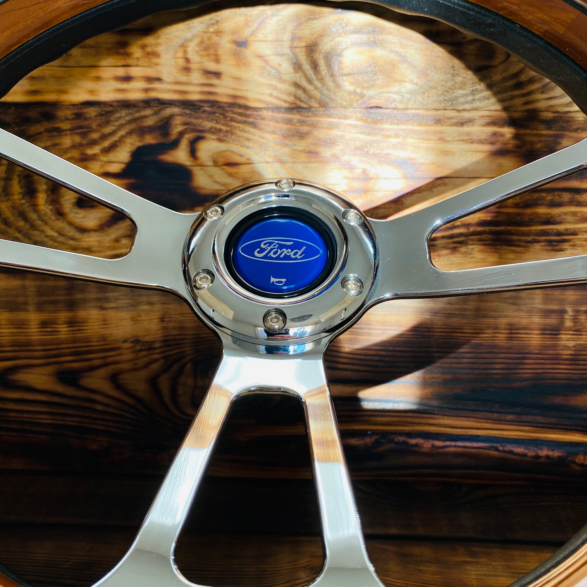 14 inch Ford wooden steering wheel by Punk Wheels with polished metal spokes and classic Ford horn button close-up