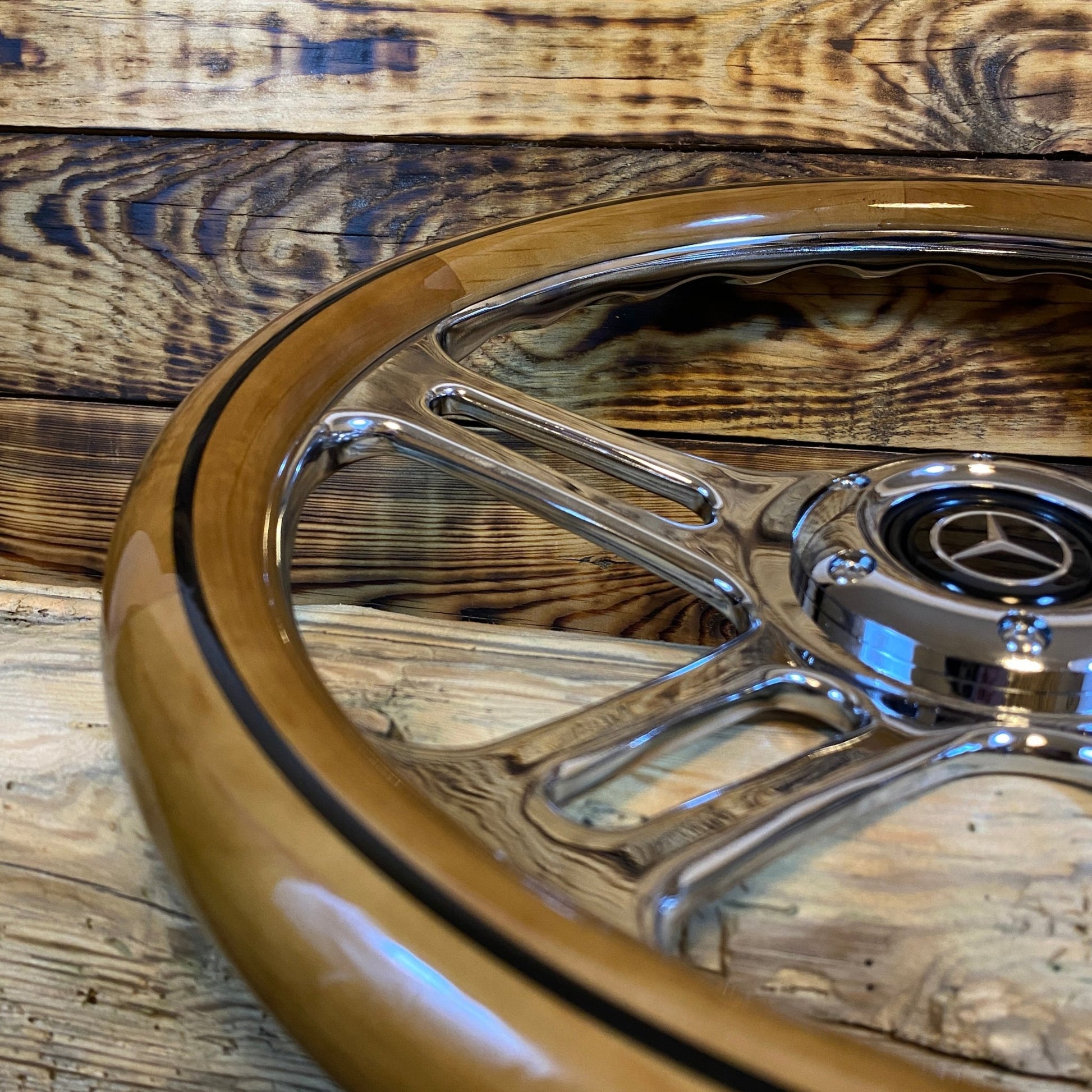 15 inch wood and chrome steering wheel for Mercedes with metal spokes close-up view on wooden surface