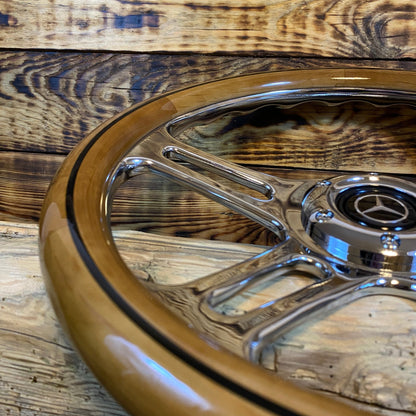 15 inch wood and chrome steering wheel for Mercedes with metal spokes close-up view on wooden surface