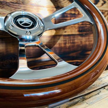 14 inch Mercedes wood steering wheel with polished metal spokes and center emblem close-up view