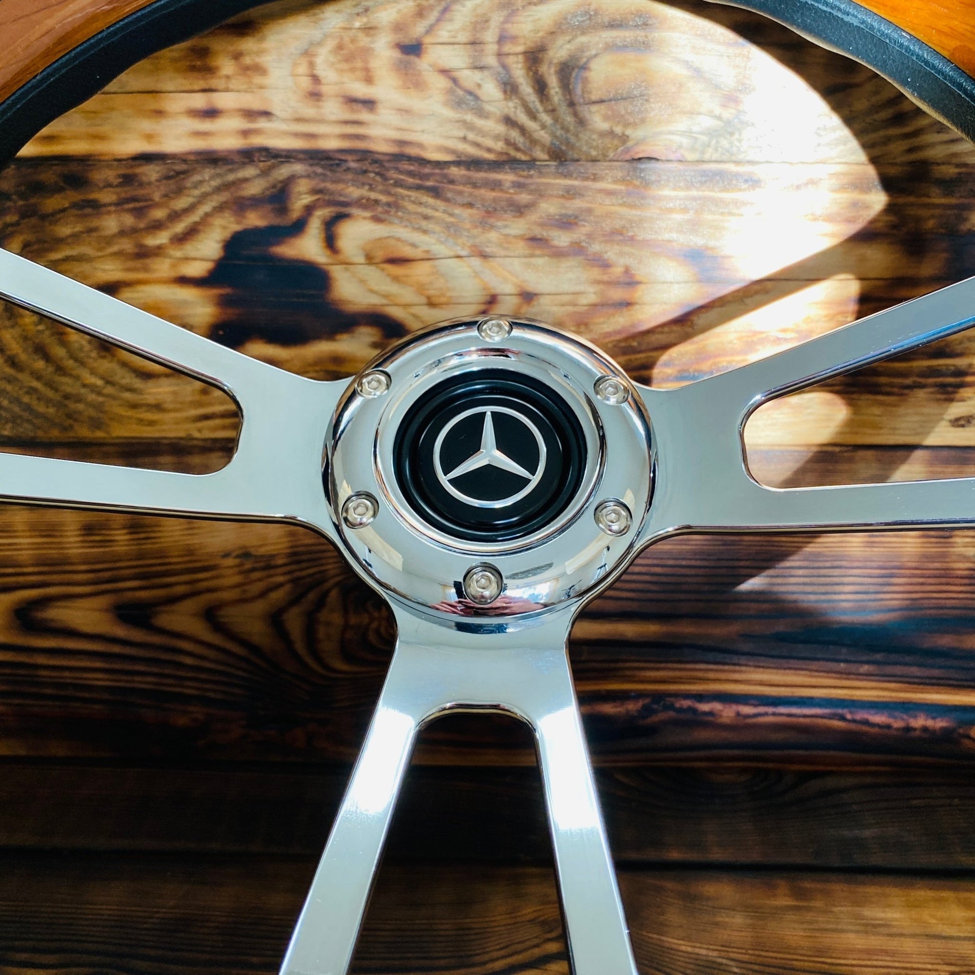 14 inch Mercedes wood steering wheel with metal spokes and center emblem front view