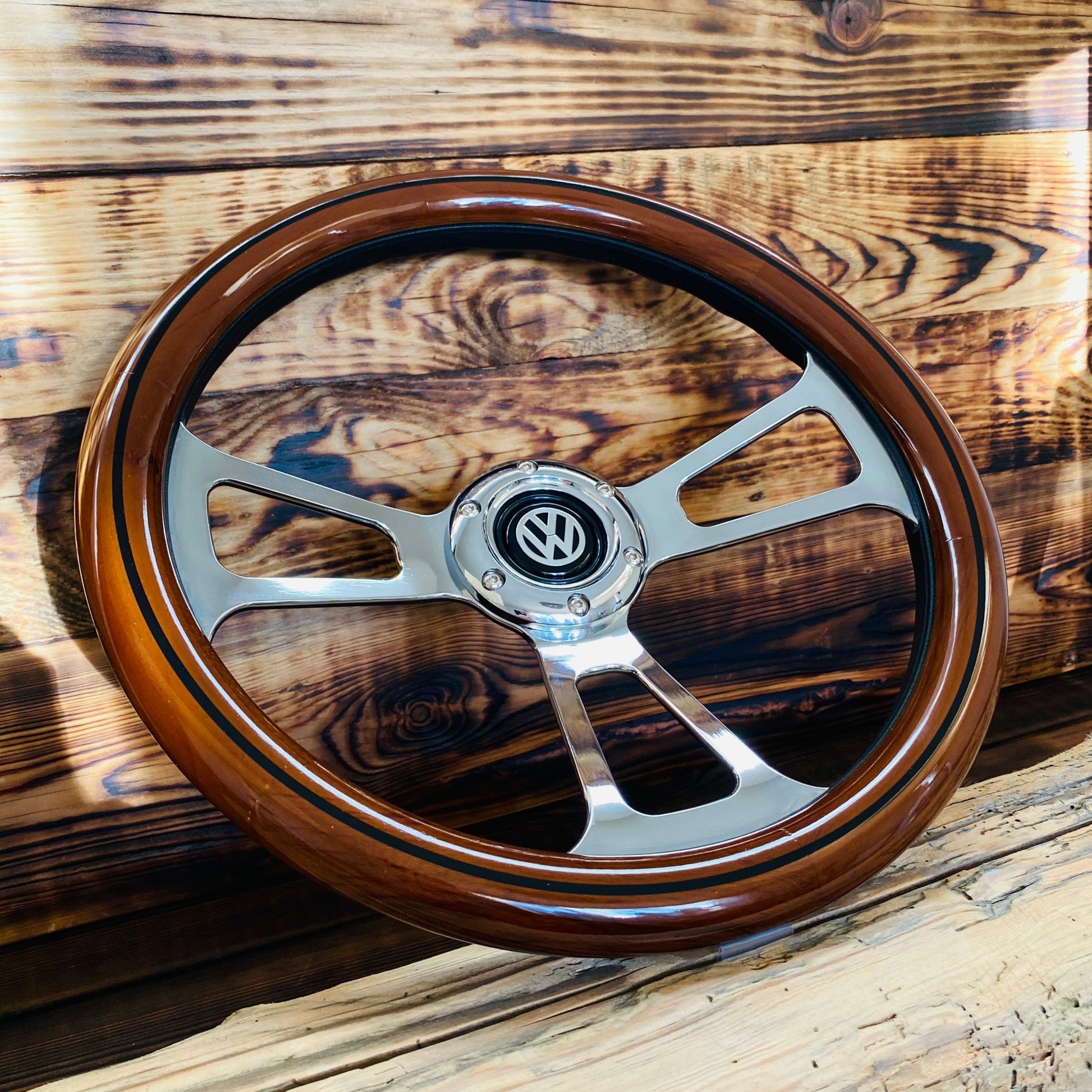 14 inch wood steering wheel for VW with polished metal spokes and black VW emblem center viewed from front