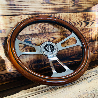 14 inch wood steering wheel for VW with polished metal spokes and black VW emblem center viewed from front