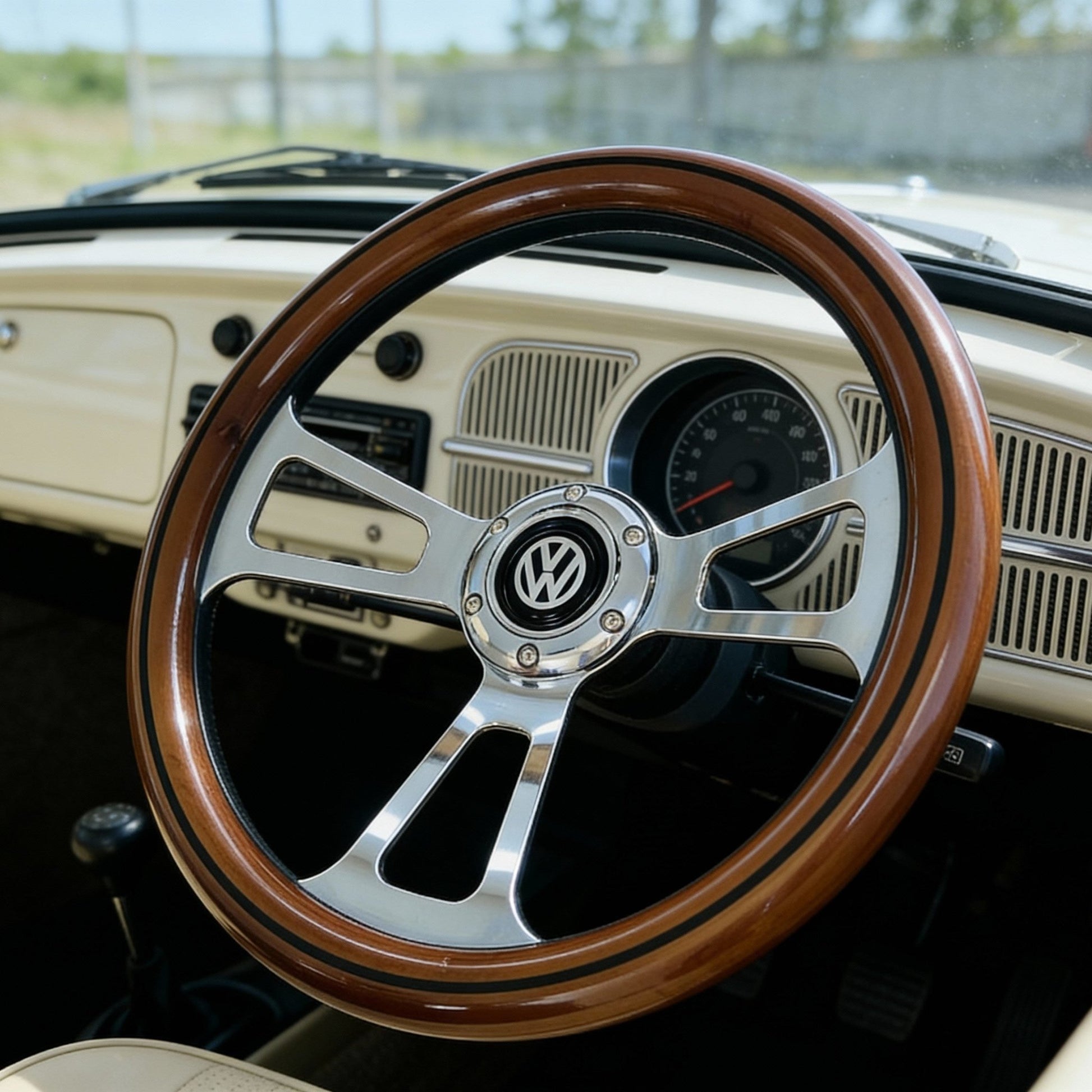 14 inch wood steering wheel for VW with polished metal spokes and VW logo center view inside classic car