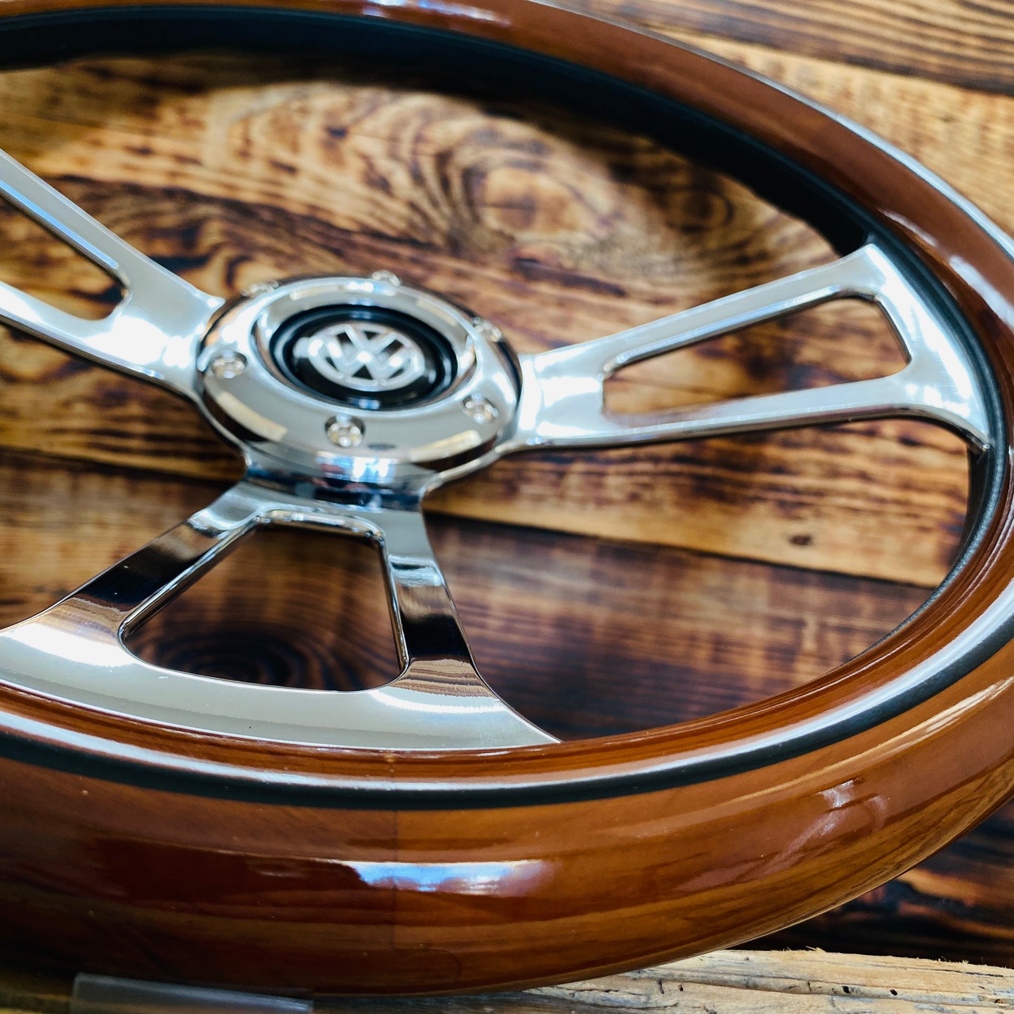 14 inch wood steering wheel for VW with polished metal spokes and Volkswagen emblem close-up view